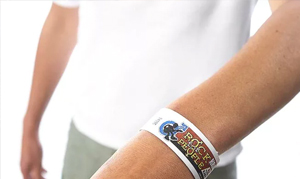 Personne portant un bracelet tyvek au poignet.